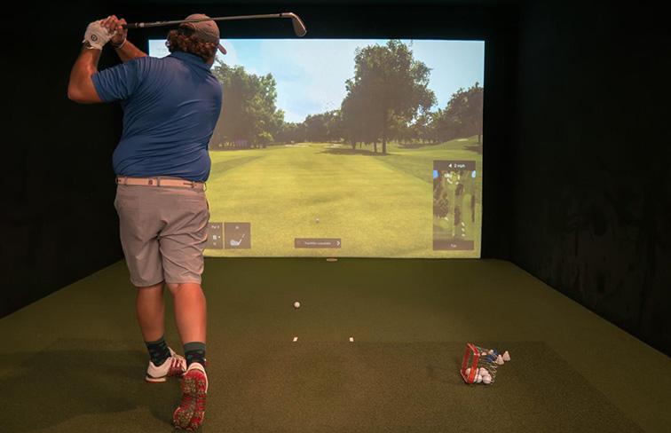 Person swinging in golf simulator